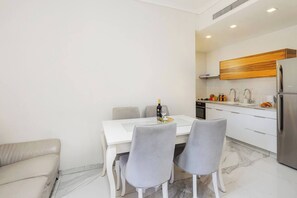 Eine moderne Küche mit weißen Schränken, einer Holzvertäfelung und einem Edelstahl-Kühlschrank.