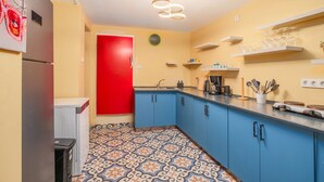 A kitchen with blue cabinets, a red door, and a patterned floor. - Comfortable Home Steps from the Kadıköy Waterfront (Istanbul)
