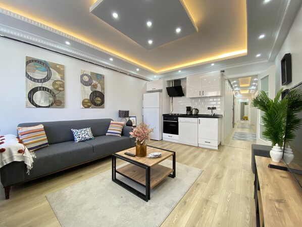 Ein modernes Wohnzimmer mit Sofa, Couchtisch und Kunstwerk an der Wand.