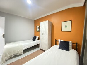 A room with two single beds, a wardrobe, and a door. - Designer 2BR Flat | Terrace + Istiklal Location (Istanbul)