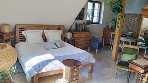 Un dormitorio con una cama de madera, un escritorio, una silla y un aparador.
