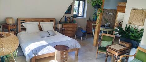 A bedroom with a wooden bed, a desk, a chair, and a dresser.