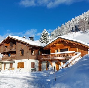 A wooden chalet with a balcony, a covered porch, and a snow-covered roof. - Family chalet in the Alps with a great view and 3 separate living areas. (Notre-Dame-de-Bellecombe)