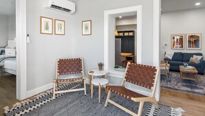 A modern living room with two brown leather chairs, a small white table, and a patterned rug. - Fully Updated 2 Bedroom Apartment in Downtown - Just Steps Away from Green Lake (Green Lake)