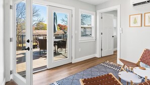 A modern interior with a sliding glass door leading to a deck, a patterned rug, and a seating area with a table and chairs. - Fully Updated 2 Bedroom Apartment in Downtown - Just Steps Away from Green Lake (Green Lake)