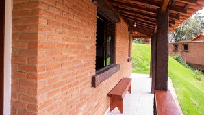A brick building with a covered porch and a bench.