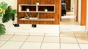 Un soggiorno con un mobile TV in legno, una TV a schermo piatto e una pianta in vaso.