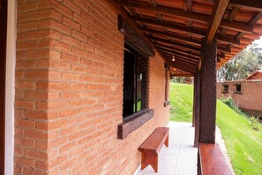 A brick building with a covered porch and a bench.
