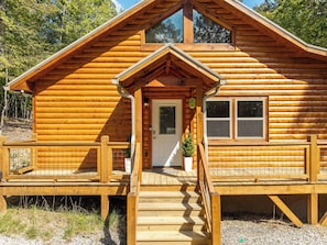 Eine Holzhütte mit Veranda, einer Tür und einem Fenster.