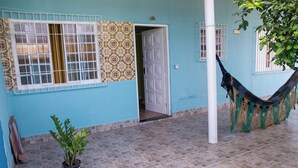 A building with a tiled floor, a hammock, and a potted plant. - Casa Pet Friendly a 950m da Praia Vista Linda (Bertioga)
