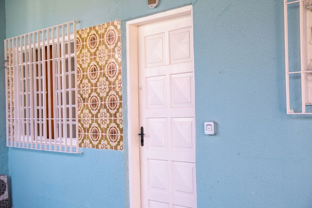 A door with a patterned window shutter and a white door frame.