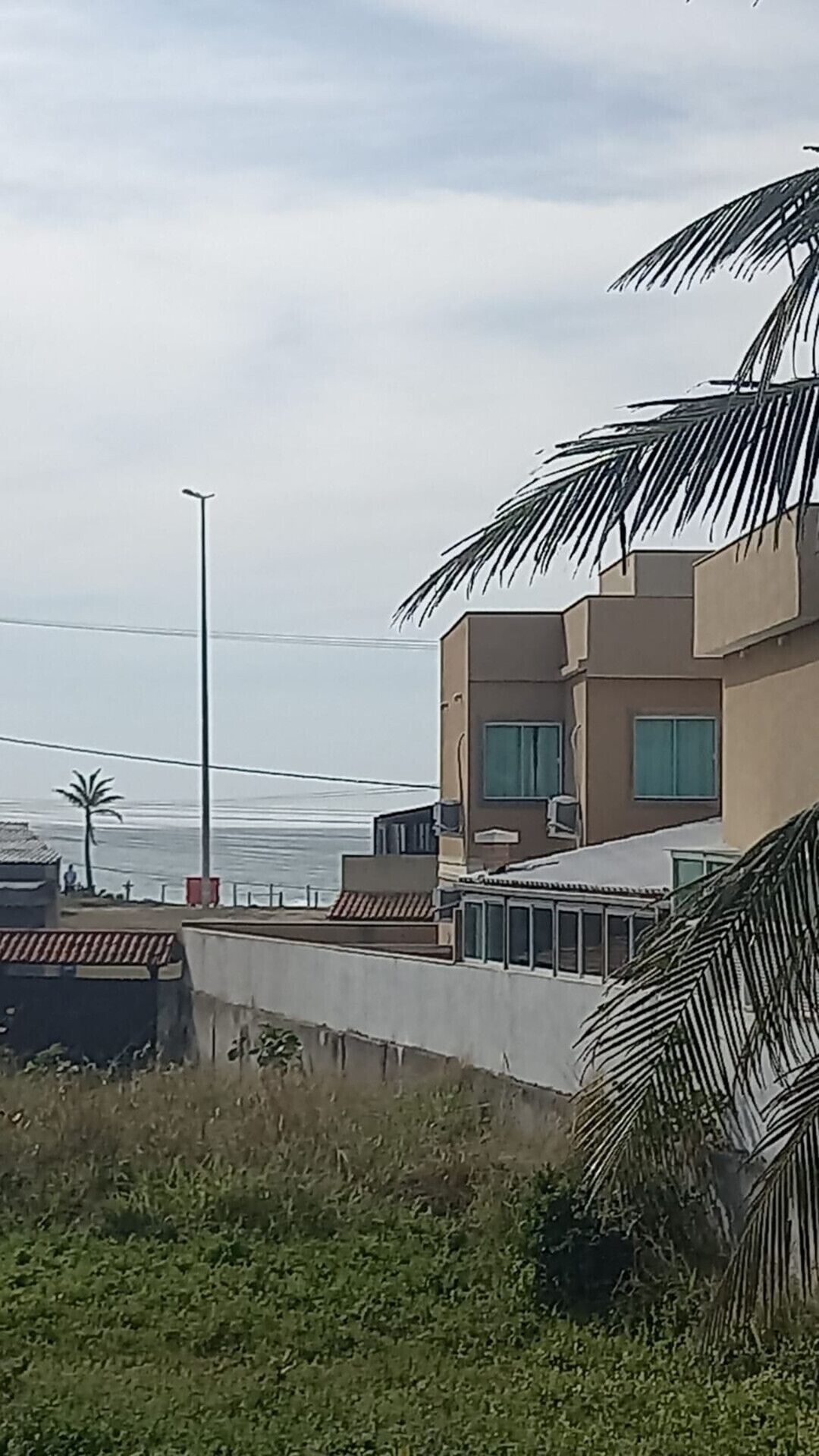 A modern building with a flat roof, large windows, and a visible air conditioning unit.