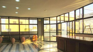 Una habitación amplia con ventanas grandes, suelo a rayas y una zona de bar.