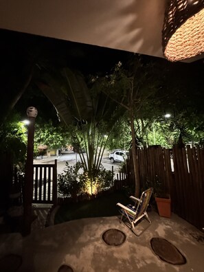 Eine Terrasse mit Holztisch und -stühlen, umgeben von einem Holzzaun und Pflanzen.