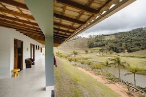 A covered outdoor area with a view of a water body and surrounding landscape. - Linda casa de campo com Wi-Fi em Santa Teresa/ES (Santa Teresa)