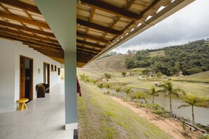 Un espace extérieur abrité offrant une vue sur un plan d’eau et le paysage environnant.