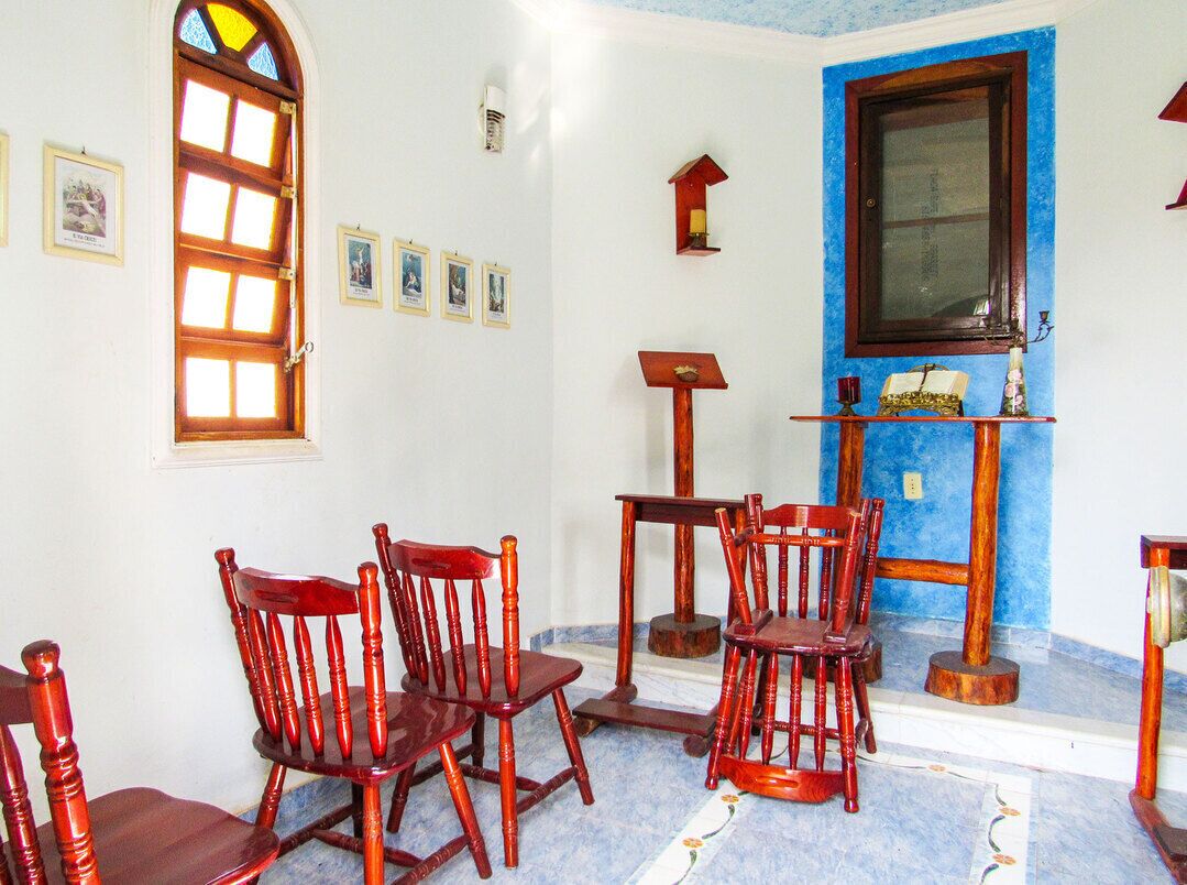 Une pièce avec une porte en bois, un mur bleu et une chaise en bois.