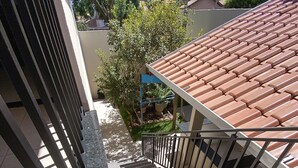 En trappe med flisegulv fører op til en balkon med flisetag.