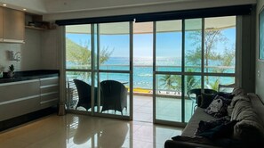Cozinha moderna com porta de vidro deslizante que dá para uma varanda com vista para o mar.