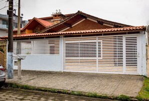 Ein Haus mit Ziegeldach, einer weißen Garagentür und einem gepflasterten Auffahrtsweg.