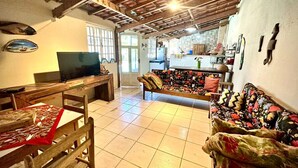 Una sala de estar acogedora con una mesa de madera, un sofá y una televisión.