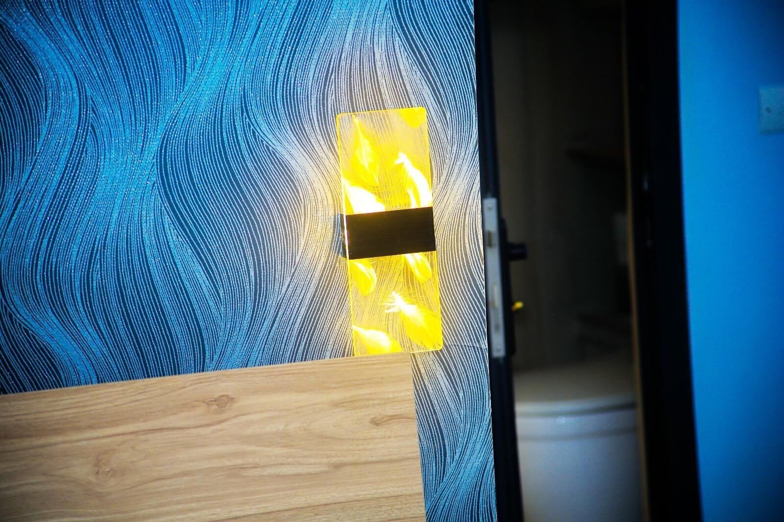Une pièce avec un mur bleu à la texture particulière et un banc en bois.