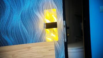 Une pièce avec un mur bleu à la texture particulière et un banc en bois.