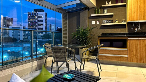 En moderne lejlighed med balkon, spiseplads og køkken.