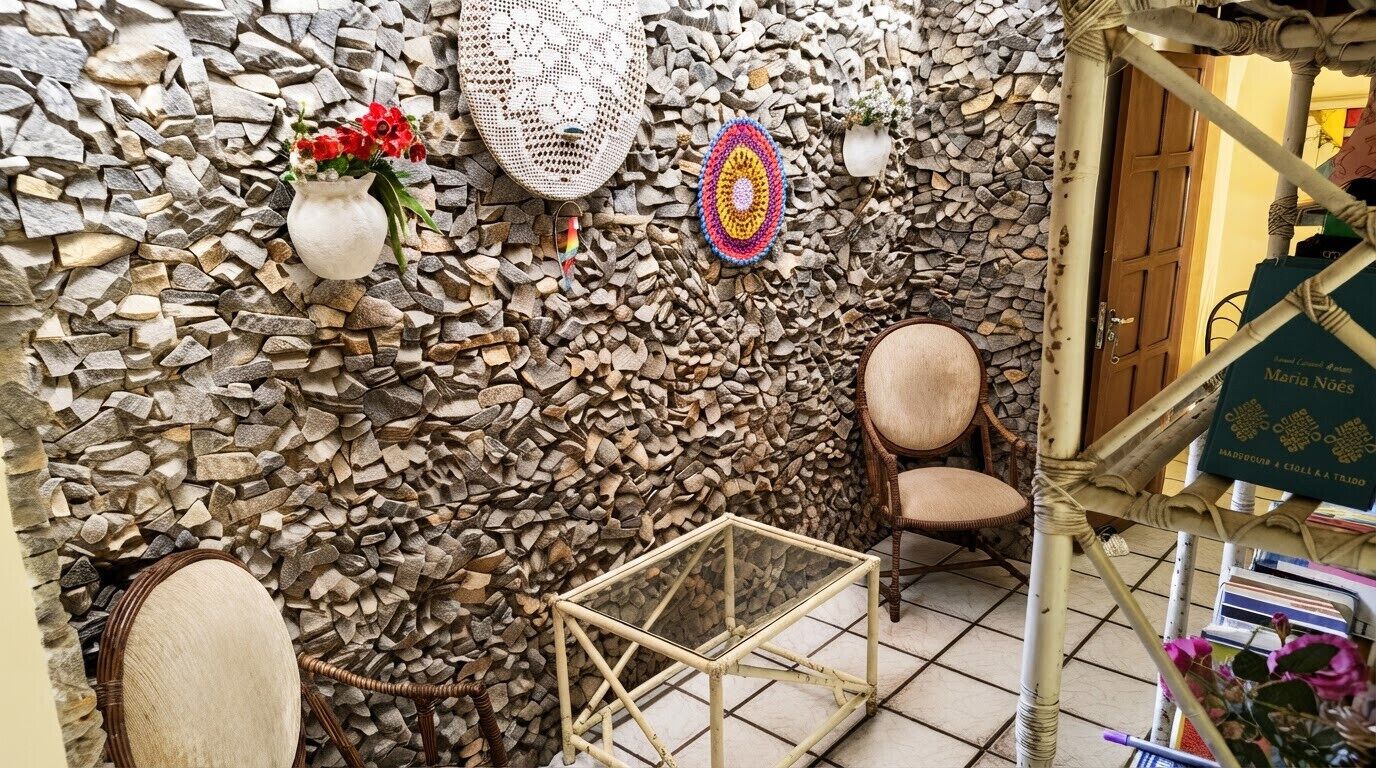 Une pièce avec un mur en pierre, une chaise en osier, une petite table et une porte sur laquelle est apposée une pancarte.