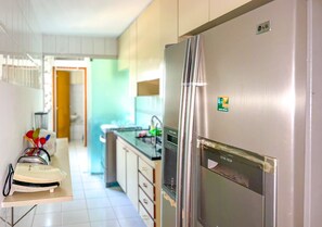 Uma cozinha moderna com eletrodomésticos de aço inoxidável, micro-ondas e geladeira.