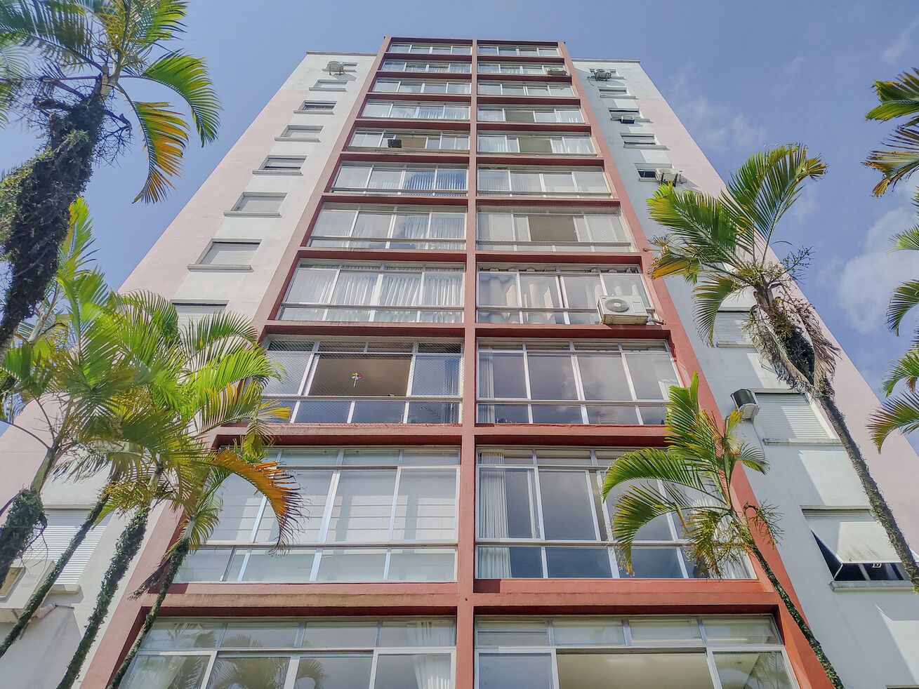 Um edifício alto com vários andares, janelas amplas e varandas.