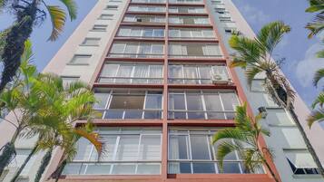 Um edifício alto com vários andares, janelas amplas e varandas.