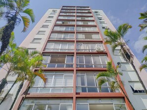 A high-rise building with multiple floors, large windows, and balconies. - Apto completo no Embaré: Beira Mar Ar Garagem (Santos)