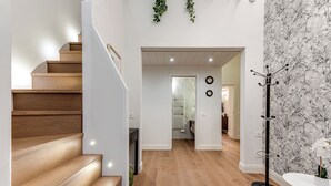 A staircase leading to a room with a white wall, a black and white patterned wallpaper, and a coat rack. - Bella Benci Frescoed Apartment Central Florence near Uffizi and Ponte Vecchio (Firenze)