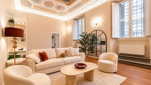 A modern living room with a sofa, two armchairs, a coffee table, and a large window with blinds. - Bella Benci Frescoed Apartment Central Florence near Uffizi and Ponte Vecchio (Firenze)