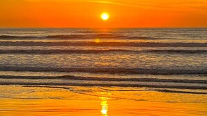 A sunset over the ocean with calm waves and a clear sky. - Casa c/ Piscina 70m da Praia do Coral | Unamar esp (Cabo Frio)