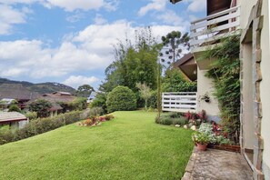 Un jardin bien entretenu, avec une pelouse, diverses plantes et une clôture blanche.