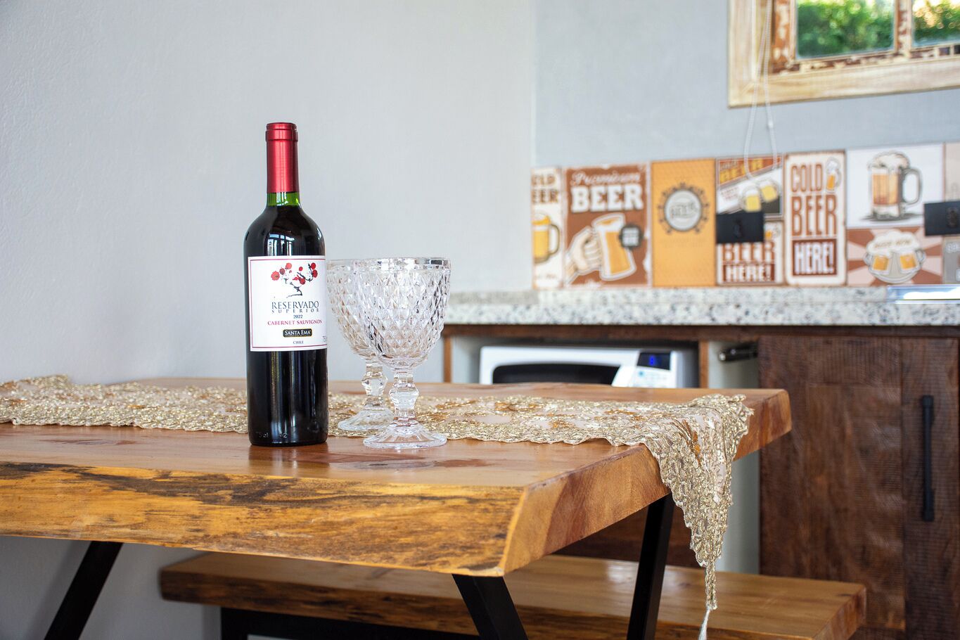 Una bottiglia di vino e un bicchiere su un tavolo di legno con una tovaglia in pizzo.
