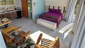 A spacious room with a large bed, a dining area, and a kitchen.