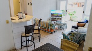 Un espacio habitable compacto con cocina, mesa de comedor y zona de estar con sillas.