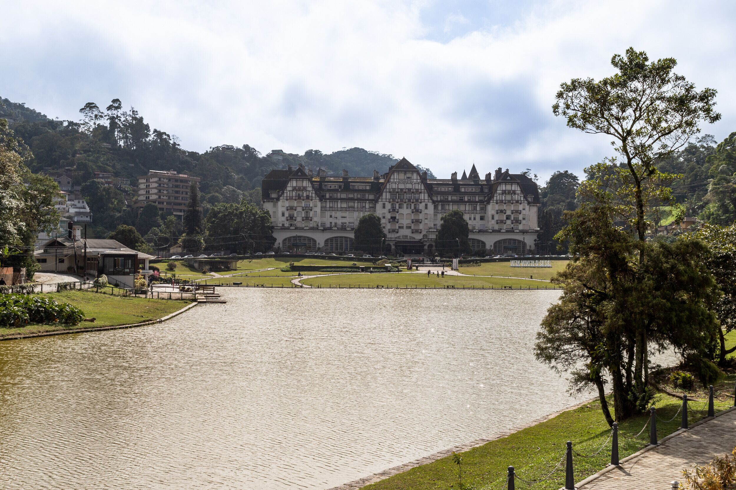 A historic building with a large courtyard and a lake in the foreground.