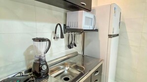 Una cucina moderna con elettrodomestici in acciaio inossidabile, tra cui un forno a microonde e un frigorifero, e un lavello integrato.
