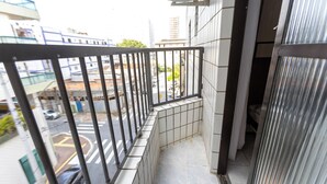 Ein Balkon mit Metallgeländer, der auf eine Straße blickt.