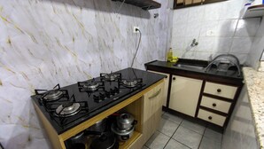 Eine Küche mit Gasherd, Holzschränken und einer Spüle.