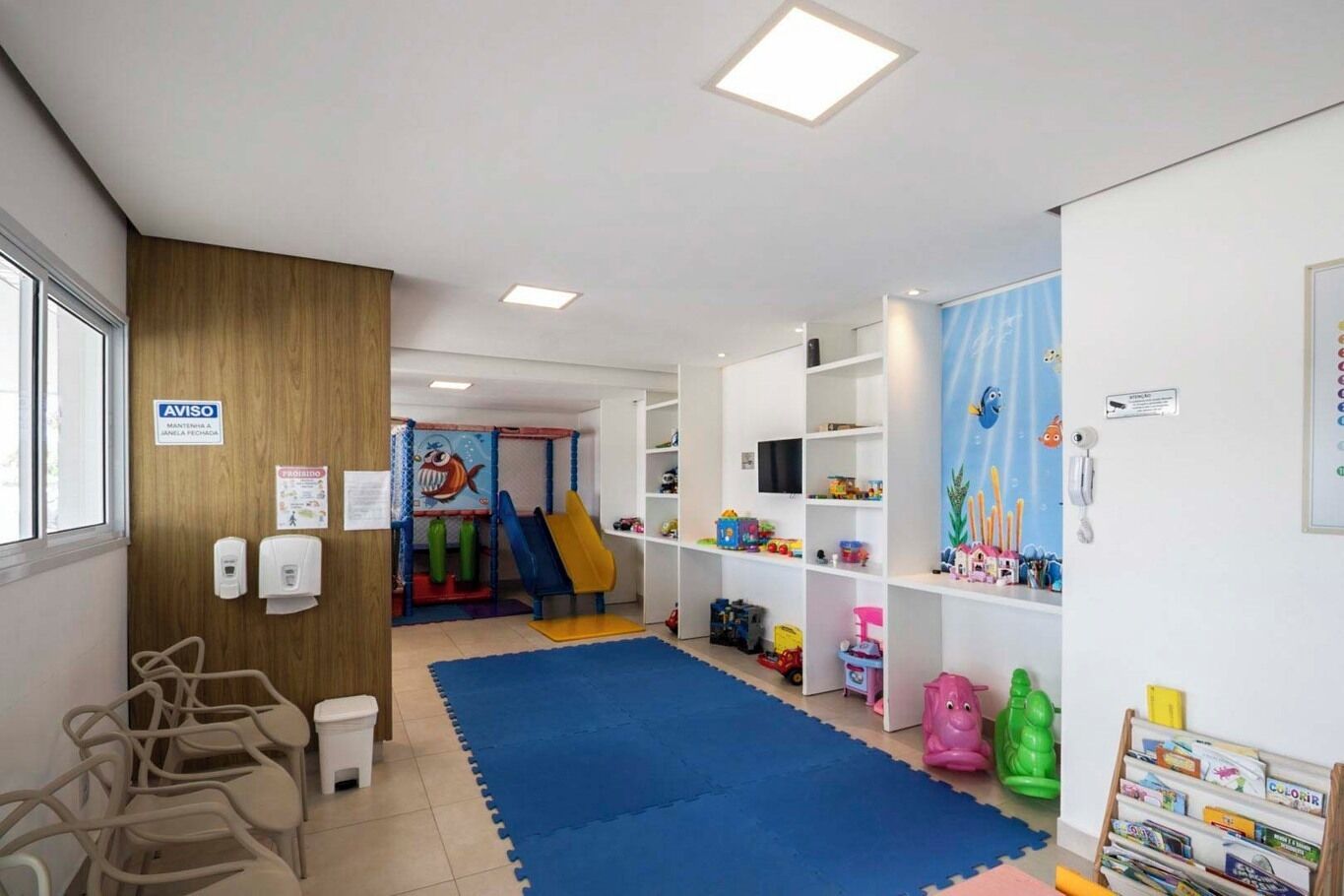 A children's play area with a slide, toys, and educational materials.