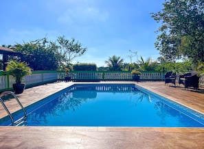 A rectangular swimming pool with a clear blue water surface, surrounded by a tiled deck.