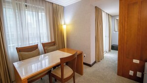 A hotel room with a wooden dining table, two chairs, a carpeted floor, and a door. - Apto no Brasil 21 - Conforto e Localização Central (Brasilia)