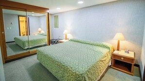 A hotel room with a bed, a nightstand, a mirror, and a lamp. - Apto no Brasil 21 - Conforto e Localização Central (Brasilia)
