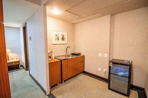 Ein kleines Hotelbad mit Waschbecken, Holzschrank und kleinem Kühlschrank.