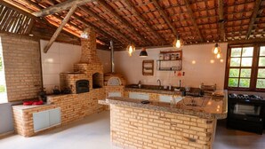 A spacious kitchen with a brick island, a built-in oven, and a large window providing natural light.